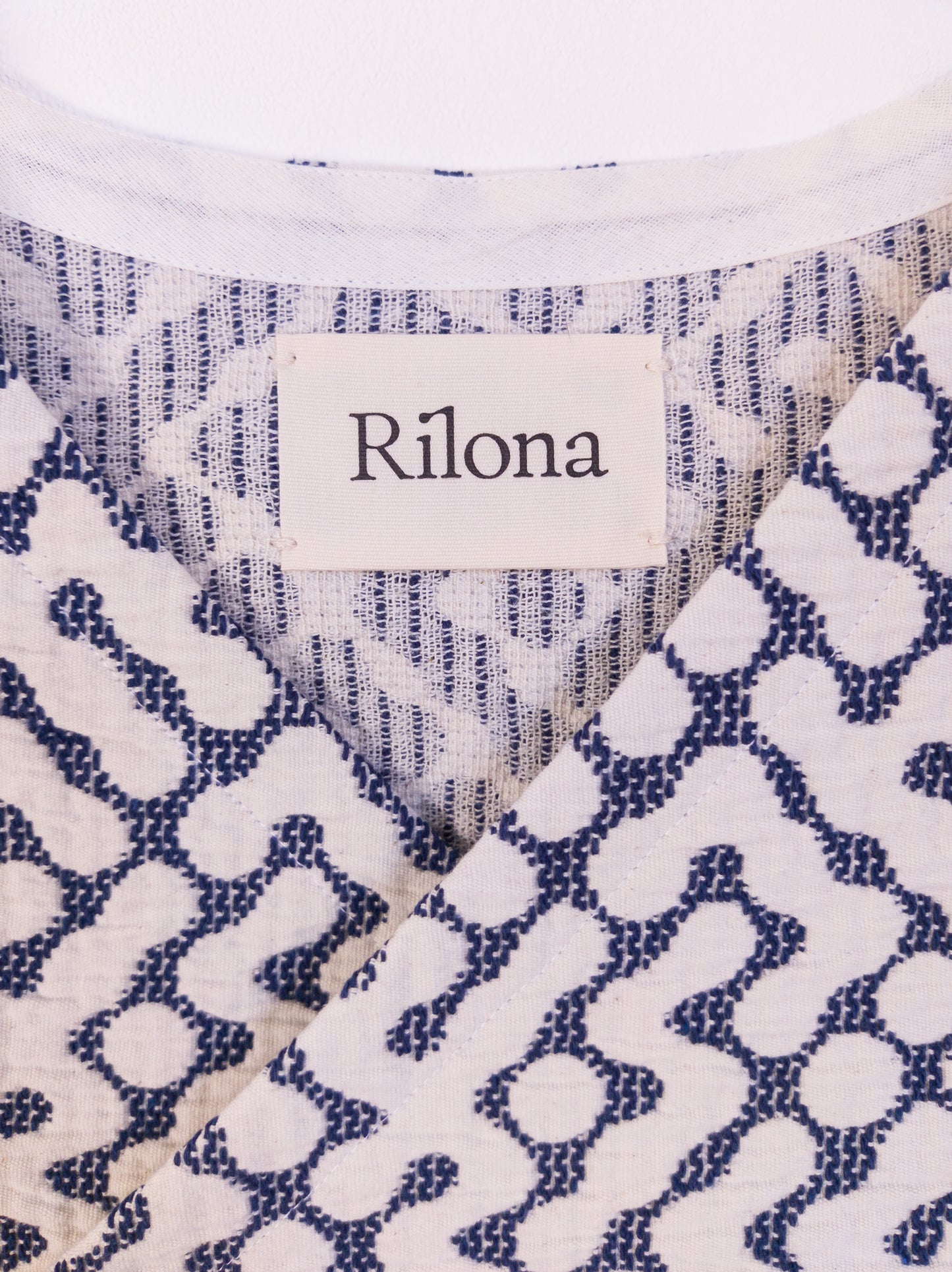 Detailansicht vom Halsloch der handgefertigten „The Orb Awakens Vest“ aus Baumwolle in Blau mit weißem kreisförmigem Muster.