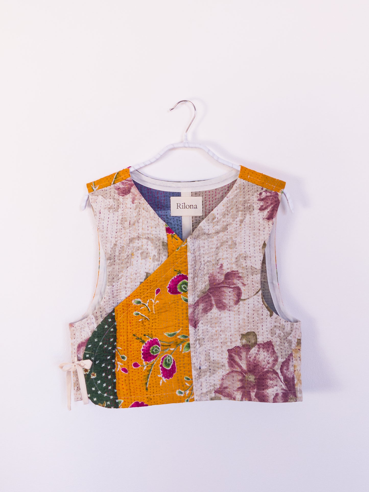 Vorderansicht der handgefertigten „Flower Patch Club Vest“ aus Baumwolle mit bunten Patchwork-Mustern und floralem Blumendruck.