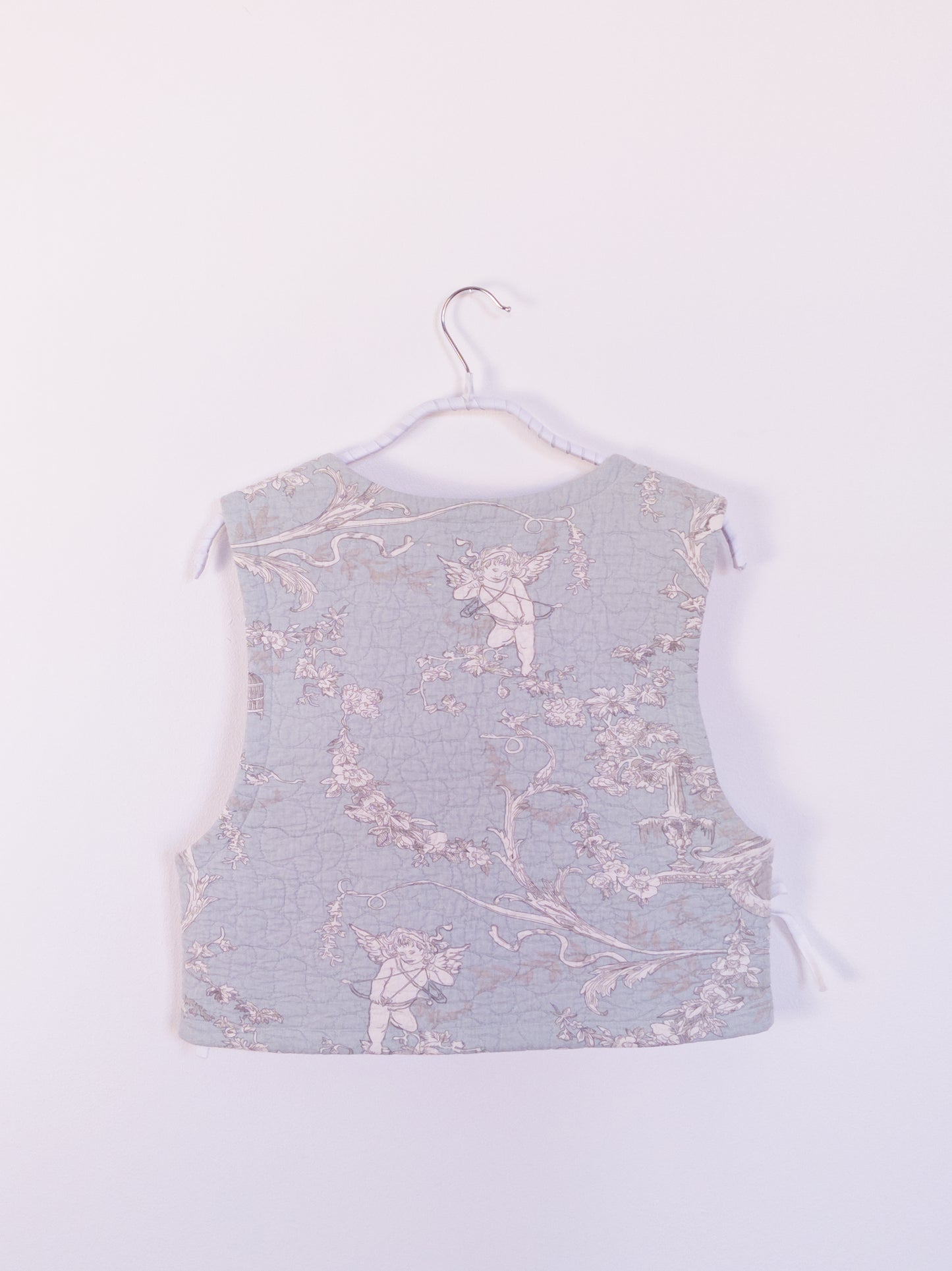 Rückansicht der „Heaven’s Stripe Club Vest“ mit himmlischen Motiven – Engel, Vogelkäfige und feine Blumenranken.