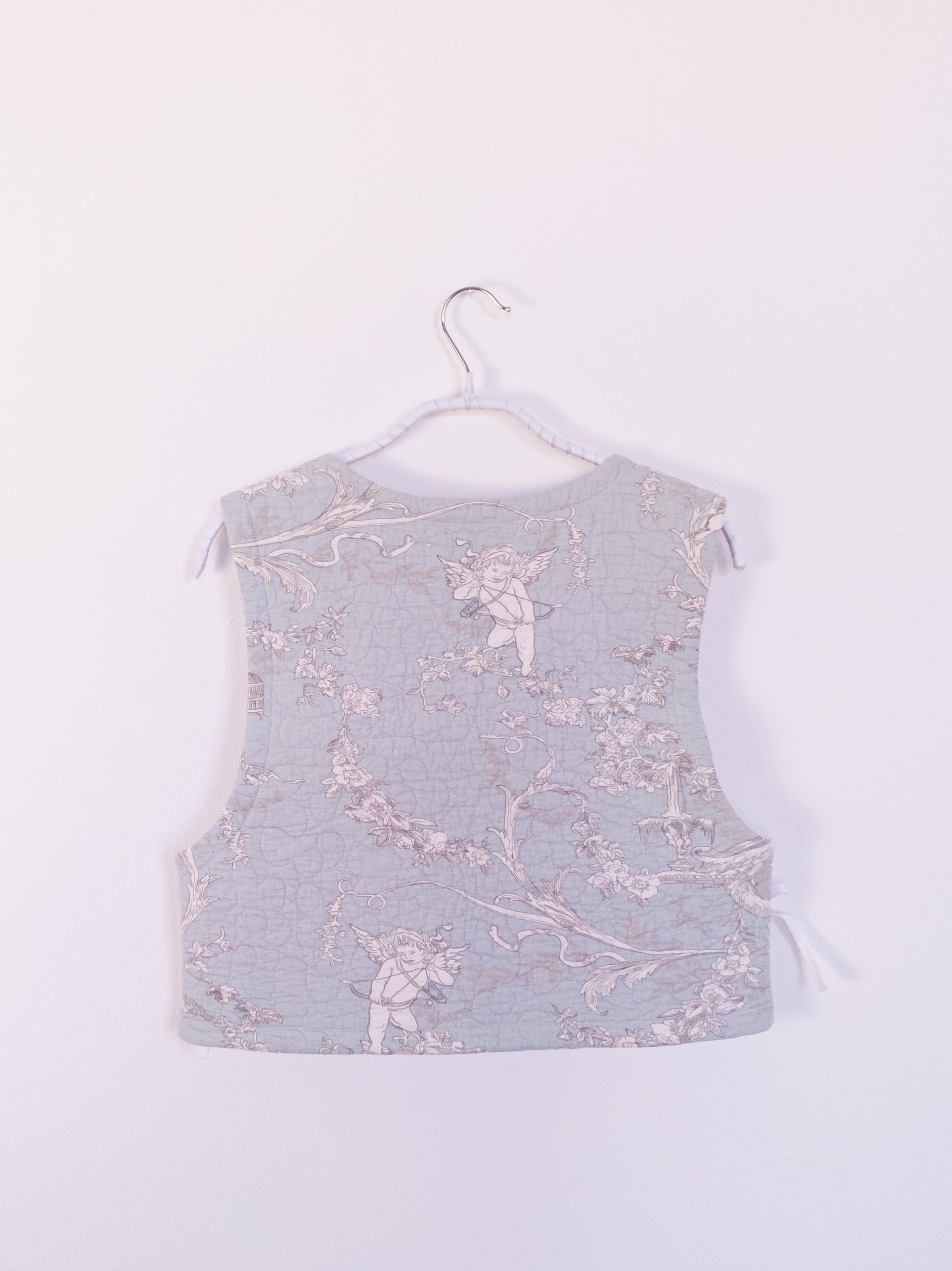 Rückansicht der „Heaven’s Stripe Club Vest“ mit himmlischen Motiven – Engel, Vogelkäfige und feine Blumenranken.