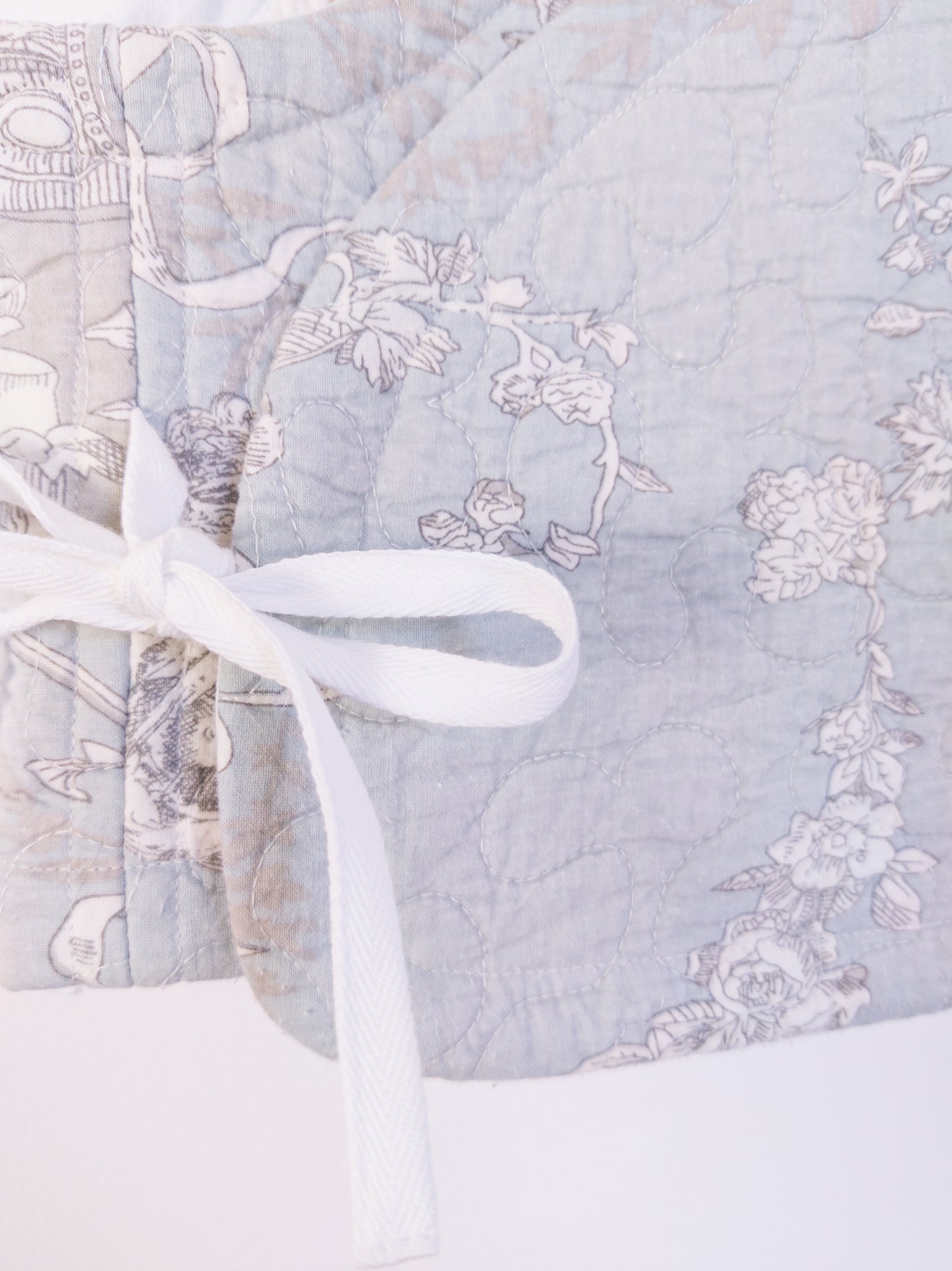 Detailaufnahme der „Heaven’s Stripe Club Vest“, zeigt die feinen Illustrationen und die Baumwollstruktur.