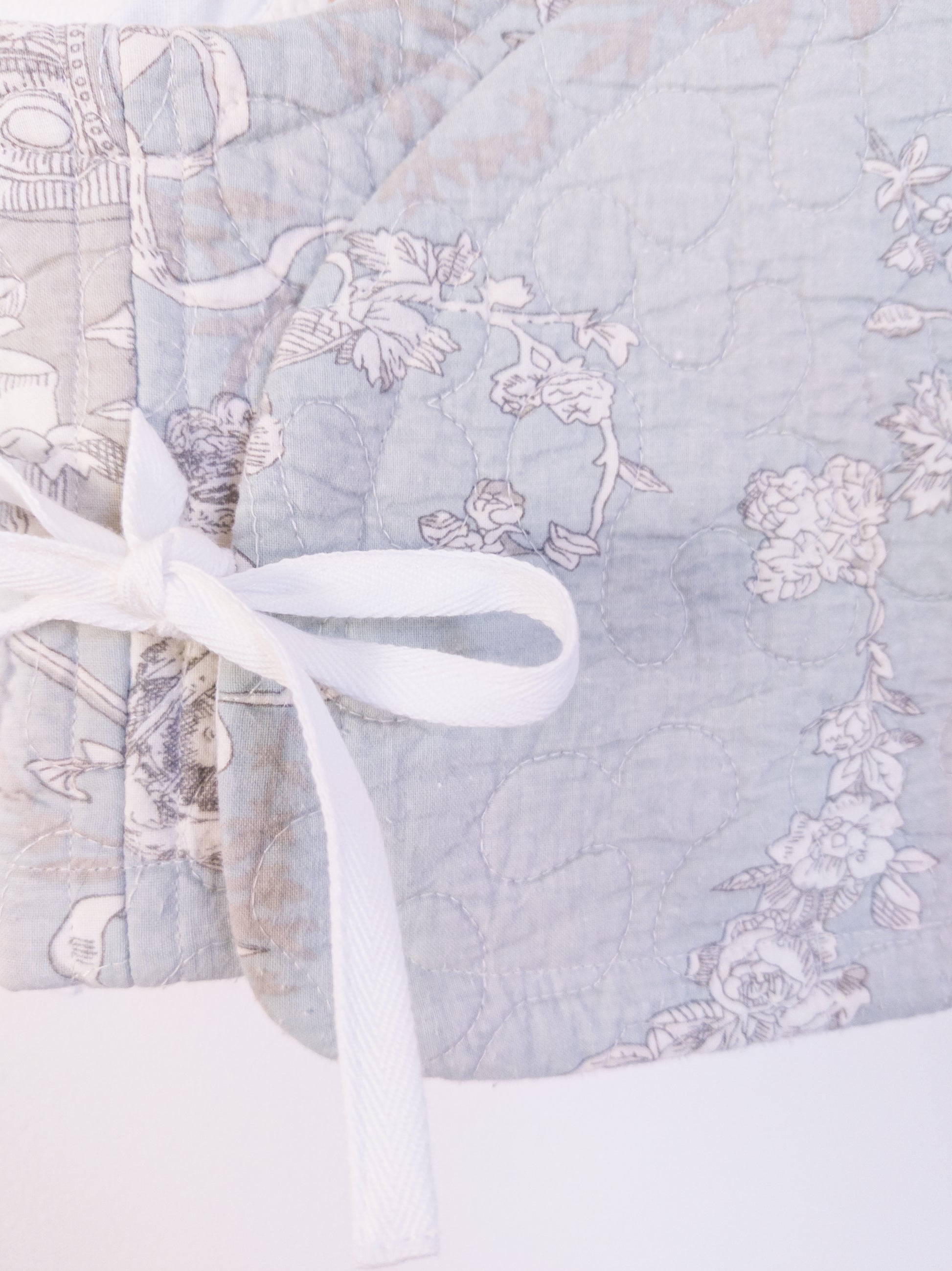 Detailaufnahme der „Heaven’s Stripe Club Vest“, zeigt die feinen Illustrationen und die Baumwollstruktur.