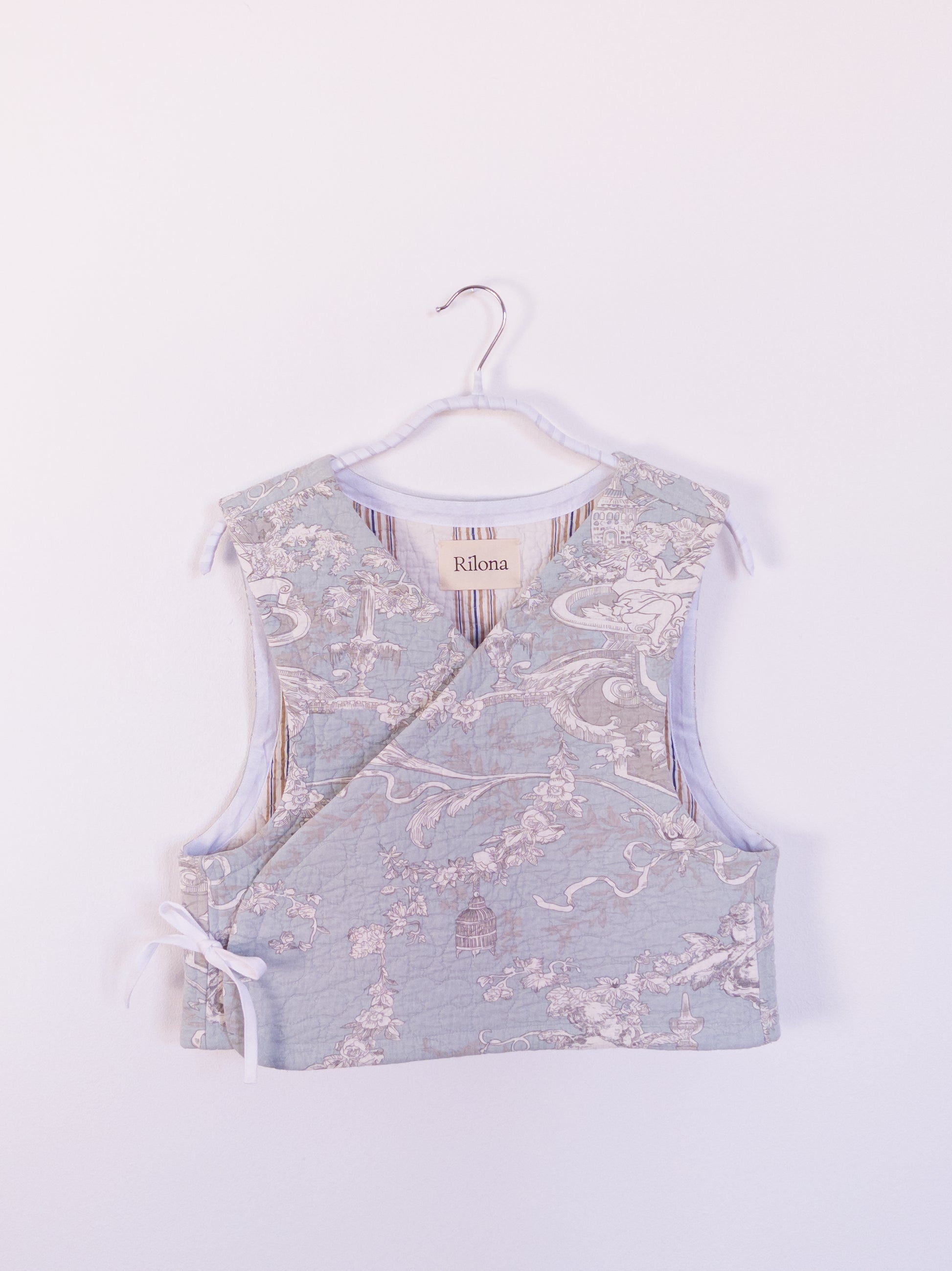 Vorderansicht der handgefertigten „Heaven’s Stripe Club Vest“ aus Baumwolle mit zartblauem Grund und cremefarbenem Engelmuster.