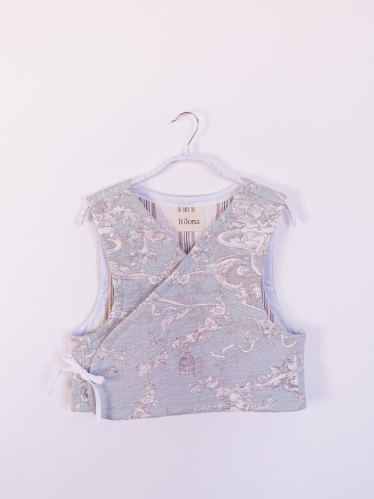 Vorderansicht der handgefertigten „Heaven’s Stripe Club Vest“ aus Baumwolle mit zartblauem Grund und cremefarbenem Engelmuster.