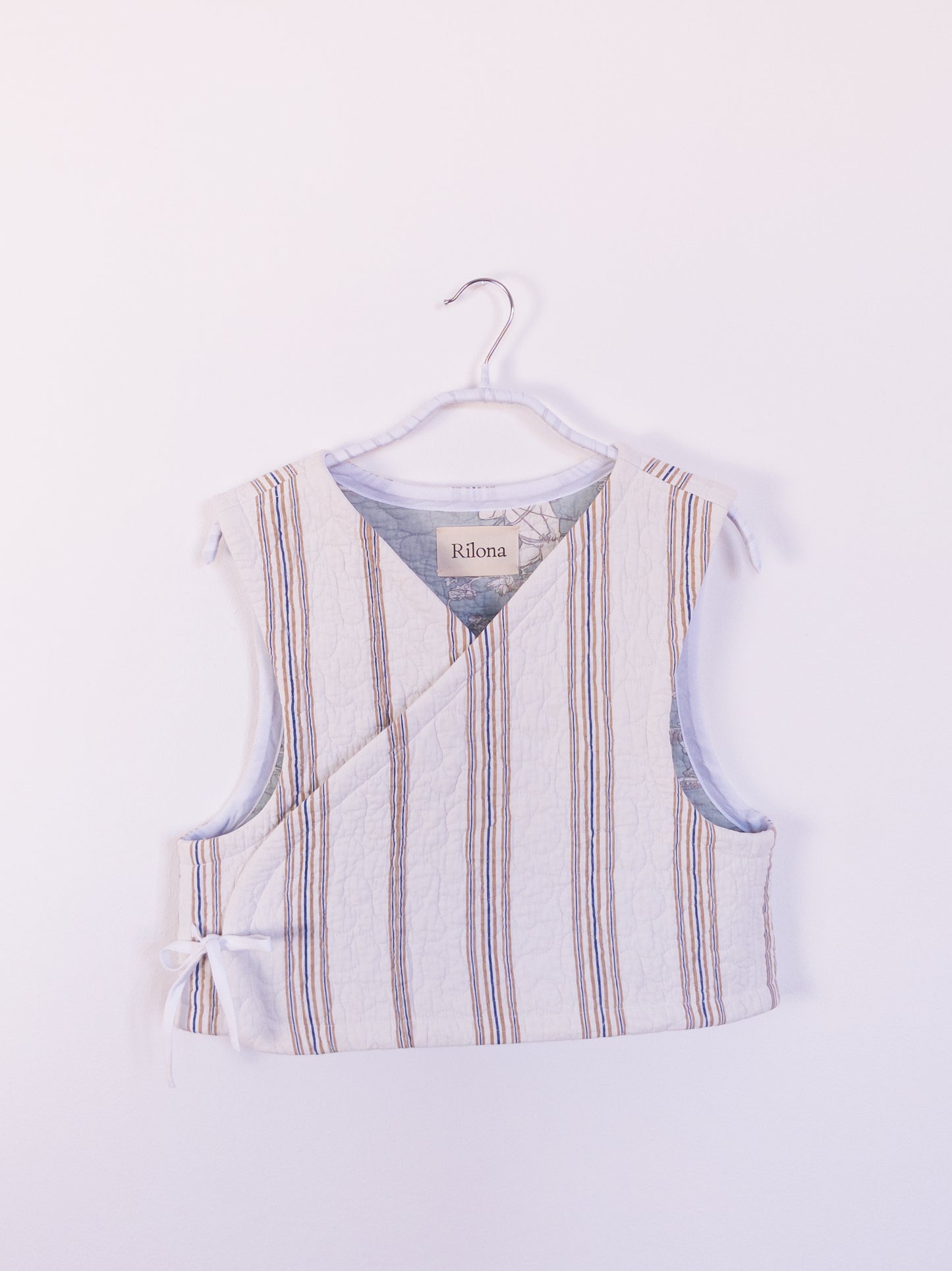 Vorderansicht der handgefertigten „Heaven’s Stripe Club Vest“ aus Baumwolle mit zarten beigen und blauen Streifen.