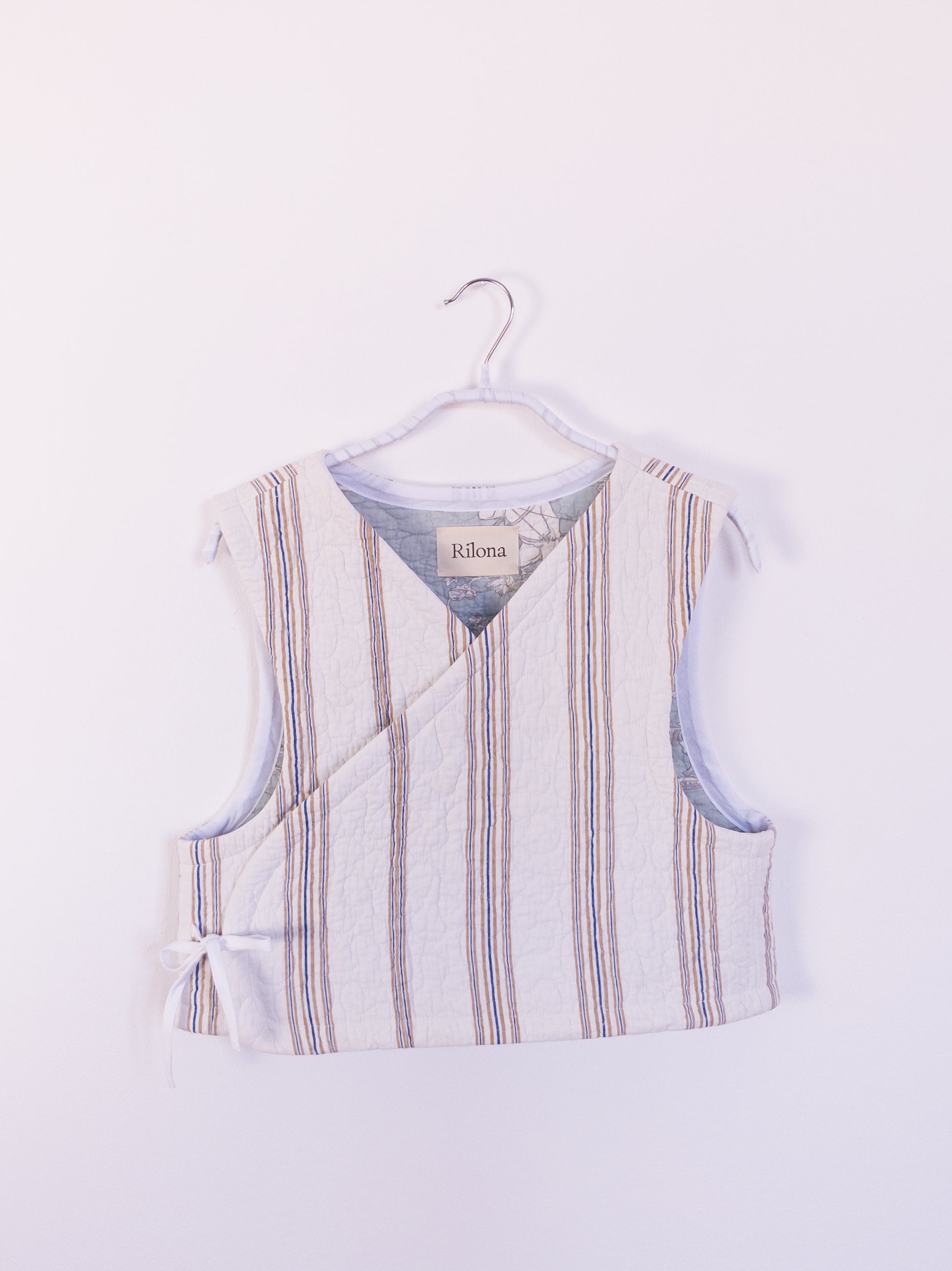Vorderansicht der handgefertigten „Heaven’s Stripe Club Vest“ aus Baumwolle mit zarten beigen und blauen Streifen.