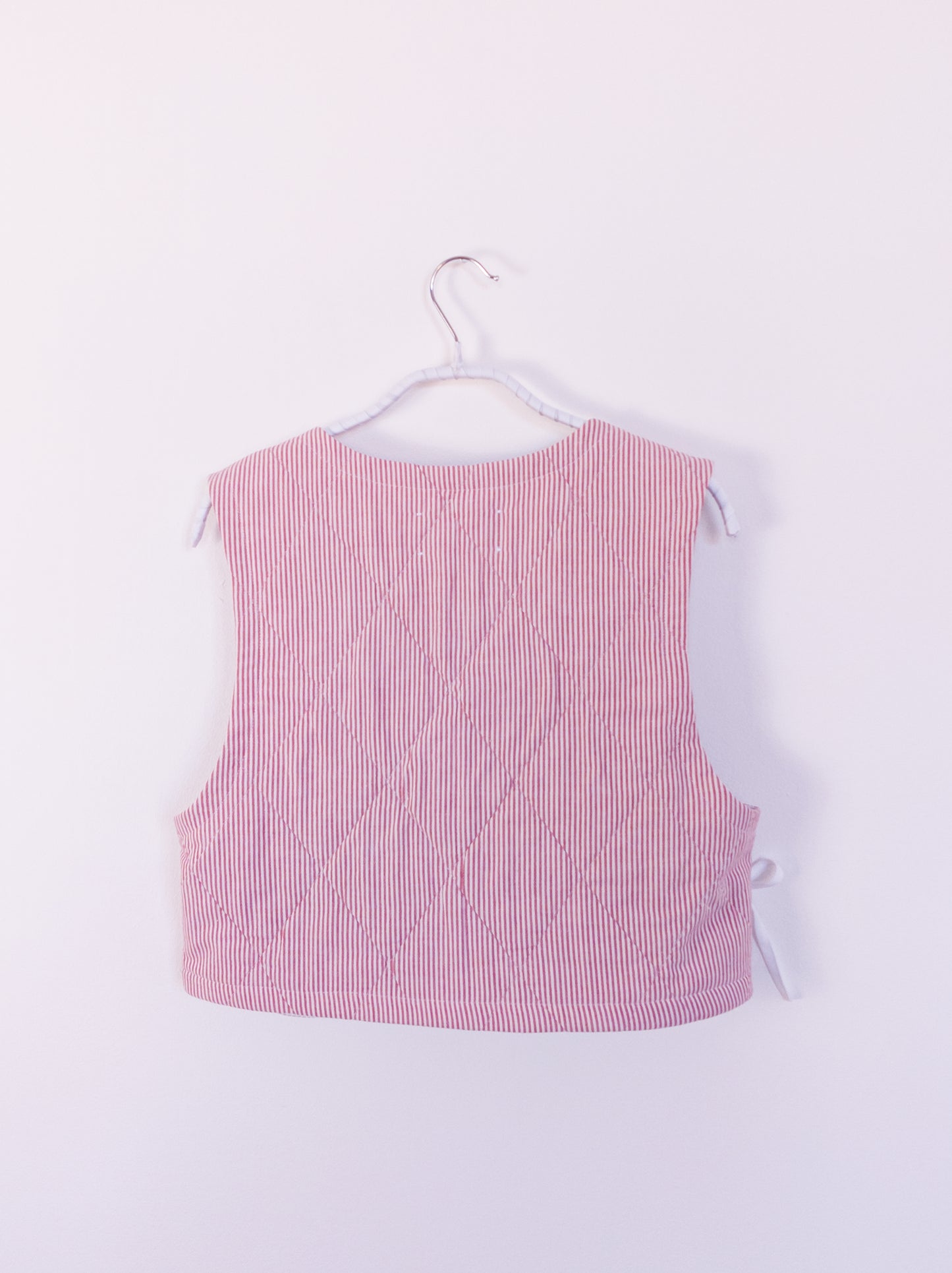 Rückansicht der „Red Hot Vest“ aus rot-weiß gestreiftem Baumwollstoff mit feiner Steppstruktur.