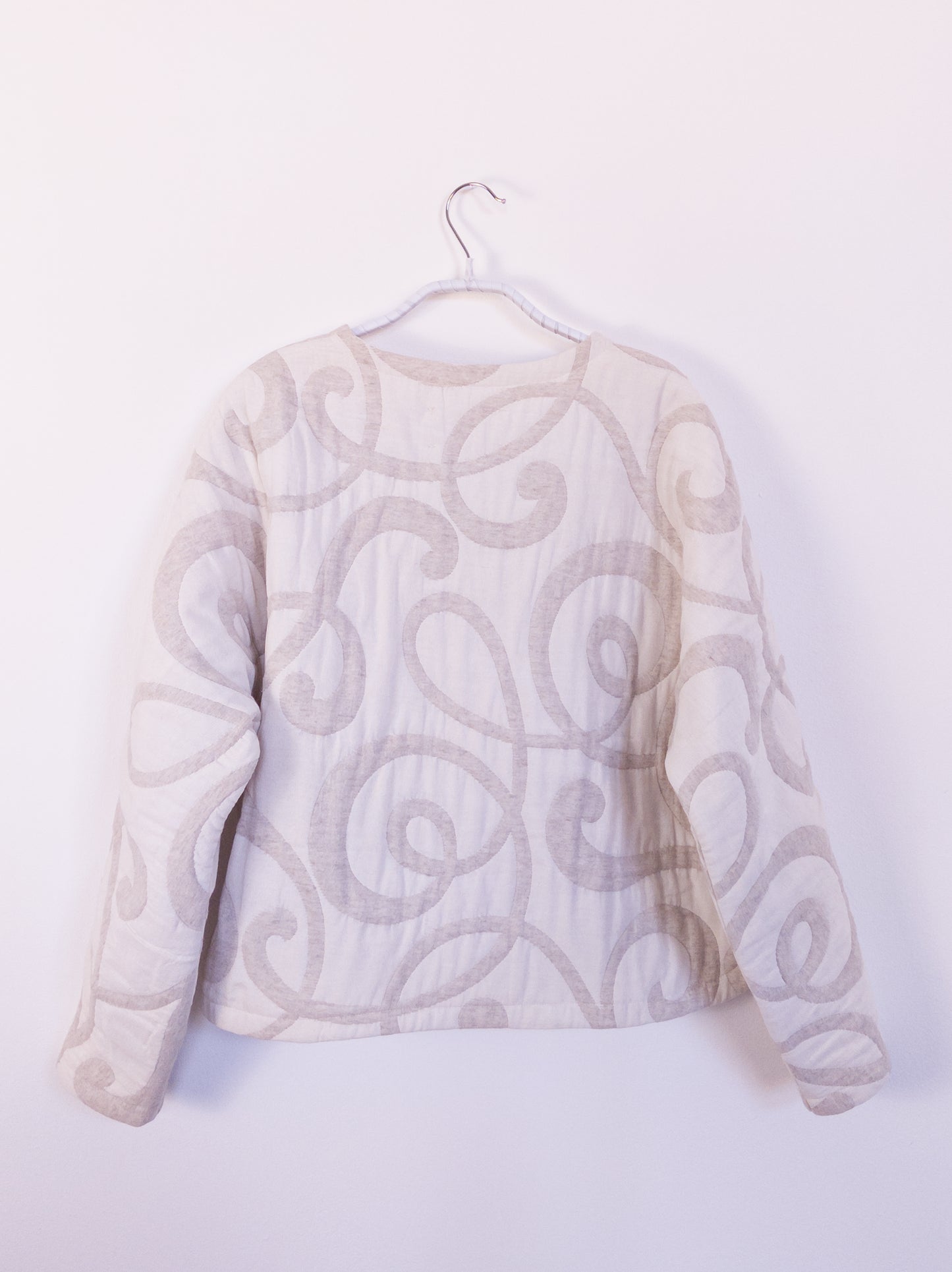 Rückansicht der „The Oatmeal Enthusiast Jacket“ aus cremefarbener Steppdecke, zeigt Struktur und handwerkliche Verarbeitung.