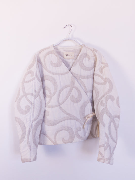 Vorderansicht der handgefertigten „The Oatmeal Enthusiast Jacket“ aus beiger Steppdecke mit feinen Schlingen, auf einem Haken hängend.